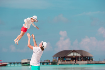 父亲和小孩子的海滩家庭享受海滩假期快乐父亲和他的可爱的小女儿热带海滩有有趣的