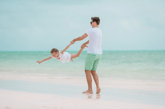快乐父亲和他的可爱的小女儿享受夏天假期快乐父亲和他的可爱的小女儿热带海滩有有趣的