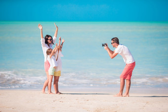 家庭四个采取自拍照片他们的海滩假期家庭海滩假期男人。采取照片他的家庭