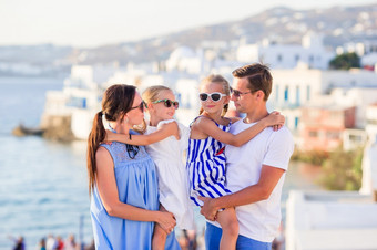 女孩蓝色的礼服有有趣的在户外米克诺斯街道父母和孩子们<strong>小威尼斯</strong>背景米克诺斯岛希腊