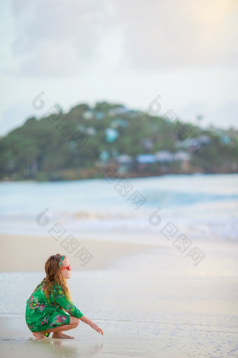 可爱的小女孩的海滩快乐女孩享受夏天假期背景的蓝色的天空和绿松石水的海快乐女孩享受夏天假期的海滩