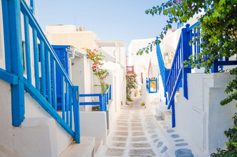 的狭窄的<strong>街道</strong>希腊岛与蓝色的阳台楼梯和花美丽的体系结构建筑外与基克拉迪群岛的风格的狭窄的<strong>街道</strong>的岛与蓝色的阳台楼梯和花