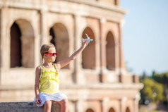 可爱的女孩与小玩具模型飞机背景罗马圆形大剧场罗马意大利年轻的女孩前面罗马圆形大剧场罗马意大利