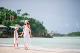 年轻的美丽的妈妈。和她的可爱的小女儿有有趣的热带海滩美丽的妈妈。和女儿加勒比海滩