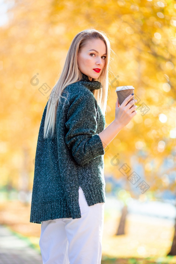 秋天秋天概念美丽的女人喝咖啡秋天公园下秋天树叶金秋天公园秋天概念美丽的女人喝咖啡秋天公园下秋天树叶