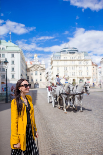 旅游女孩<strong>享受</strong>她的欧洲假期维也纳和看的美丽的马的马车旅游女孩<strong>享受</strong>她的欧洲假期维也纳
