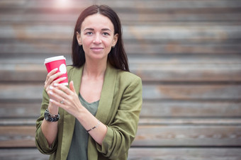 高加索人女人喝咖啡而relxing户外电影肖像女孩与咖啡的<strong>公园</strong>女人喝美味的咖啡在户外的<strong>公园</strong>