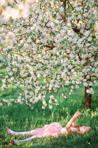 可爱的小女孩盛开的樱桃花园美丽的春天一天可爱的小女孩盛开的樱桃树花园春天一天