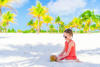 小可爱的女孩与大椰子的海滩小可爱的女孩与大椰子白色桑迪海滩