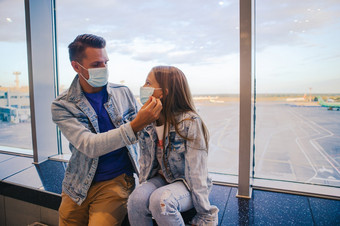 家庭脸面具机场父亲和孩子穿口罩在冠状病毒和流感爆发保护对冠状病毒和抓手爸爸和小女孩与医疗面具机场保护对冠状病毒和抓手