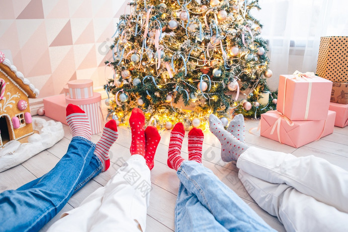 关闭照片家庭脚羊毛袜子的圣诞节树家庭四个圣诞节假期关闭照片家庭脚羊毛袜子的圣诞节树
