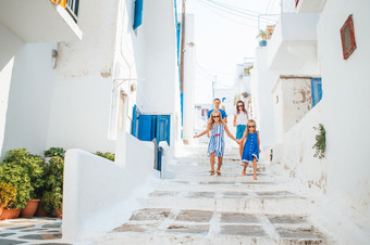 家庭假期欧洲父母和孩子们街典型的希腊传统的村与白色墙和色彩斑斓的门米克诺斯岛希腊家庭假期欧洲父母和孩子们街典型的希腊传统的村与白色墙和色彩斑斓的门米克诺斯岛