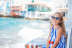 可爱的小女孩小威尼斯的大多数受欢迎的旅游区域米克诺斯岛希腊美丽的孩子小威尼斯背景