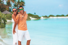 年轻的家庭两个白色海滩享受假期年轻的夫妇白色海滩在夏天假期