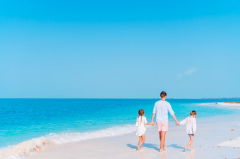 快乐父亲和可爱的小孩子们热带海滩有有趣的家庭假期快乐父亲和他的可爱的小女儿热带海滩有有趣的