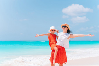 年轻的美丽的妈妈。和她的可爱的小女儿有有趣的热带海滩美丽的妈妈。和女儿加勒比海滩享受夏天假期