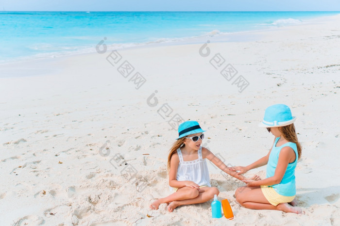 女孩应用防晒霜每一个其他的海滩的概念保护从紫外线辐射保护妹妹把防晒霜她的小妹妹rsquo鼻子