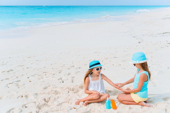 女孩应用防晒霜每一个其他的海滩的概念保护从紫外线辐射保护妹妹把防晒霜她的小妹妹rsquo鼻子