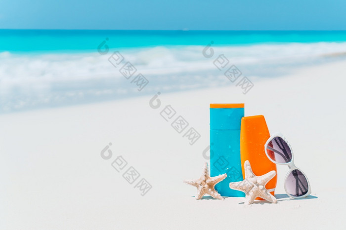 防晒霜瓶护目镜海星和太阳镜白色沙子海滩背景海洋防晒霜瓶太阳镜海星白色桑迪海滩