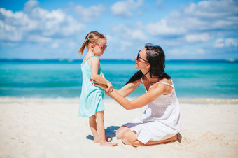 年轻的美丽的妈妈。和她的小女儿的海滩美丽的妈妈。和女儿的海滩享受夏天假期