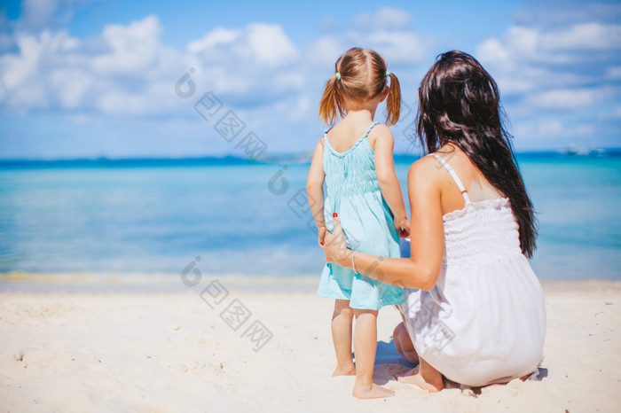 年轻的美丽的妈妈。和她的小女儿的海滩美丽的妈妈。和女儿的海滩享受夏天假期