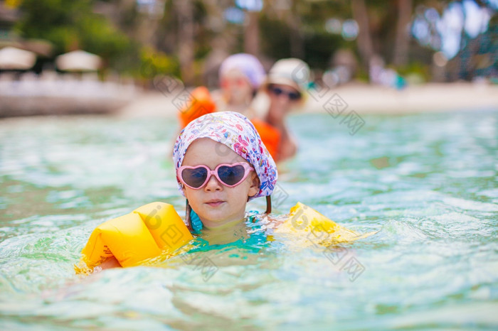 小快乐女孩溅清晰的Turquiose水可爱的小女孩海滩在夏天假期