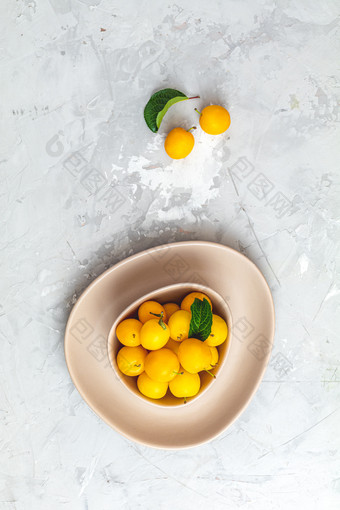 有创意的夏天模式使新鲜的黄色的樱桃李子粉红色的碗灰色的混凝土背景水果最小的概念平躺