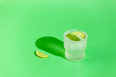 新鲜的莫吉托鸡尾酒与石灰薄荷和冰玻璃与水滴绿色背景明亮的太阳光莫吉托让人耳目一新饮料复制空间夏天假期和聚会，派对概念