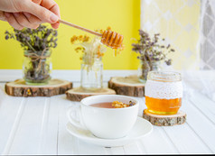 白色杯茶与林登自然有机草本植物和Jar蜂蜜白色木表格增加免疫力的很酷的季节白色杯茶与林登自然有机草本植物和Jar蜂蜜白色木表格