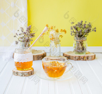 玻璃杯茶与林登自然有机草本植物和Jar蜂蜜白色木表格增加免疫力的很酷的季节玻璃杯茶与林登自然有机草本植物和Jar蜂蜜白色木表格