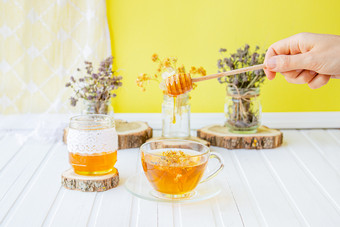 玻璃杯茶与林登自然有机草本植物和Jar蜂蜜白色木表格增加免疫力的很酷的季节玻璃杯茶与林登自然有机草本植物和Jar蜂蜜白色木表格