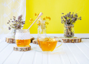 玻璃杯茶与林登自然<strong>有机</strong>草本植物和Jar<strong>蜂蜜</strong>白色木表格增加免疫力的很酷的季节玻璃杯茶与林登自然<strong>有机</strong>草本植物和Jar<strong>蜂蜜</strong>白色木表格