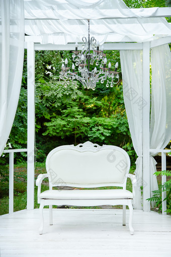 夏天优雅的优雅的露台的郁郁葱葱的花园精致的经典沙发露台与白色窗帘新鲜的花园夏天优雅的优雅的露台的郁郁葱葱的花园精致的经典沙发露台