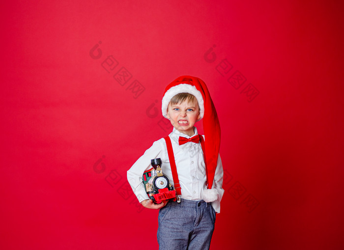 快乐圣诞节可爱的快乐的小男孩圣诞老人老人他红色的背景快乐童年与梦想和礼物特写镜头婴儿开放口牛奶牙下降了出快乐圣诞节可爱的快乐的小男孩圣诞老人老人他红色的背景