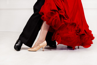 关闭舞者脚舞厅舞者的跳舞地板上男人。裤子女人华丽的舞厅红色的衣服关闭舞者脚舞厅舞者的跳舞地板上
