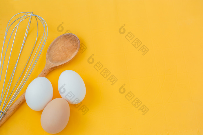 成分为烹饪鸡蛋和厨房工具木表格前视图食谱与三个鸡蛋成分为烹饪鸡蛋和厨房工具木表格前视图