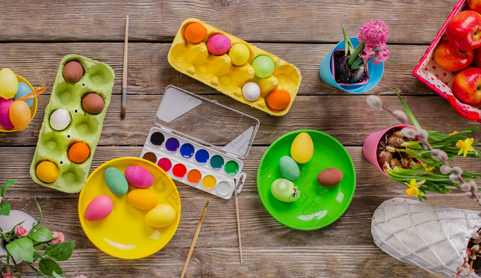 复活节快乐家庭将油漆鸡蛋和得到准备好了为复活节前视图的表格与油漆和鸡蛋复活节快乐家庭将油漆鸡蛋和得到准备好了为复活节