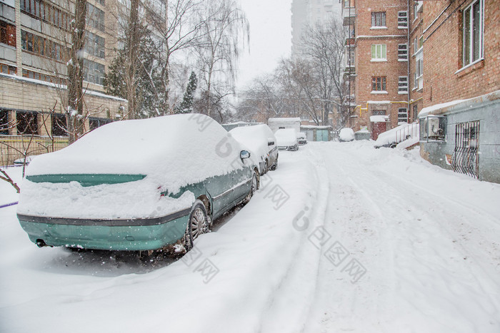 车辆覆盖与雪冬天暴雪的停车很多白雪覆盖的道路和街道的城市车辆覆盖与雪冬天暴雪的停车很多