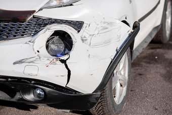 检查的车后事故的路车事故事故的前面翼和的正确的头灯是破碎的损害和划痕的保险杠破碎的车部分特写镜头车事故事故的前面翼和的正确的头灯是破碎的损害和划痕的保险杠破碎的车部分特写镜头