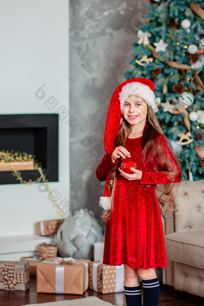 一个可爱的快乐的女孩圣诞老人他附近圣诞节树持有红色的圣诞节球快乐圣诞节一个可爱的快乐的女孩圣诞老人他附近圣诞节树持有红色的圣诞节球