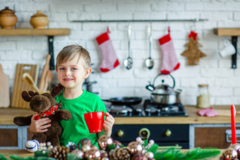好早....小男孩饮料茶的厨房表格和拥抱泰迪驼鹿时间奇迹和实现欲望快乐圣诞节好早....小男孩饮料茶的厨房表格和拥抱泰迪驼鹿时间奇迹和实现欲望