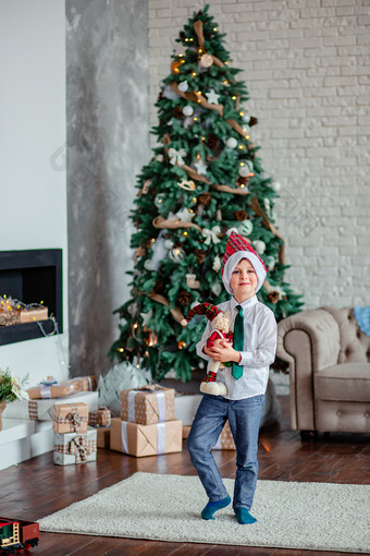 可爱的一个男孩解包礼物下的圣诞节树坐着的壁炉圣诞节早....快乐圣诞节可爱的一个男孩解包礼物下的圣诞节树坐着的壁炉圣诞节早....