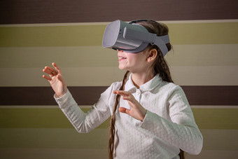 女孩与虚拟现实耳机的女孩探讨了的世界虚拟现实通过视频和游戏技术的未来女孩与虚拟现实耳机的女孩探讨了的世界虚拟现实通过视频和游戏