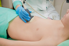 女医生工作与超声波扫描仪检查病人胃临床考试少年的胃女医生工作与超声波扫描仪检查病人胃