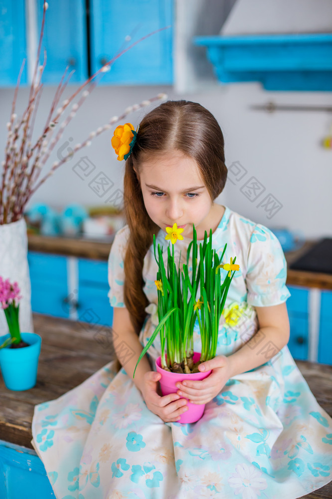 漂亮的女孩持有能水仙花花期待春天和复活节节日情绪漂亮的女孩持有能水仙花花期待春天和复活节