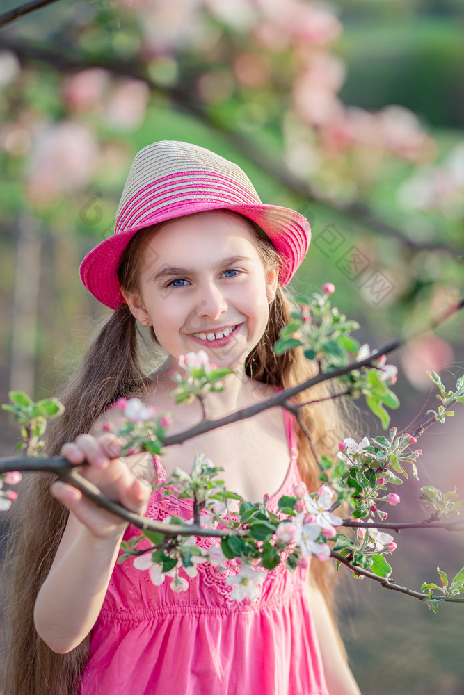 一个可爱的女孩的花园与盛开的樱桃和苹果树女孩玩在户外一个可爱的女孩的花园与盛开的樱桃和苹果树