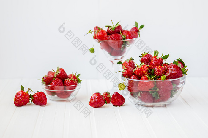 红色的成熟的草莓玻璃碗白色木表格收获从你的花园的概念健康的吃红色的成熟的草莓玻璃碗白色木表格收获从你的花园