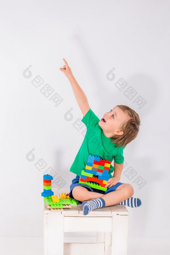 小男孩玩与很多色彩斑斓的塑料块构造函数室内小男孩玩与很多色彩斑斓的塑料块构造函数