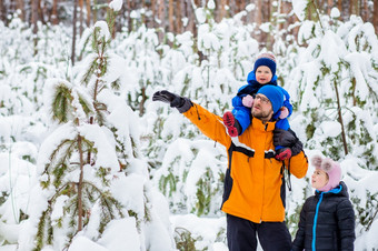 父亲走与他的年轻的孩子们的森林冬天冬天活动的雪雪橇和雪球父亲走与他的年轻的孩子们的森林冬天