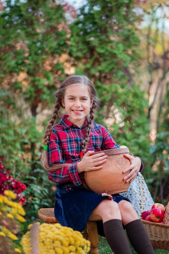 可爱的小女孩拥抱南瓜的秋天花园庆祝秋天收获可爱的小女孩拥抱南瓜的秋天花园
